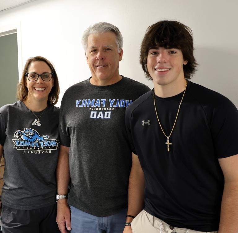 A Holy Family student and his parents smiling with the text 'Access the Parent Portal'